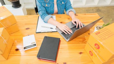 Küçük girişimciler ürünlerini sarı paket kutulara yerleştirerek KOBİ işlerini evde başlatıyorlar. Fikir, sipariş almak ve sevkiyat yapmak için dizüstü bilgisayarlarla internet üzerinden satış yapmaya başlamak..