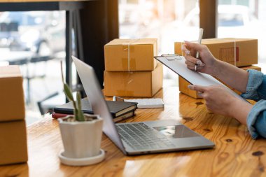 Küçük işletme girişimi Asyalı KOBİ Girişimcileri Ev, Ofis, Depo, Çevrimiçi Pazarlama Paketi Siparişleri Almak için Kutu ve Laptop ile çalışıyorlar. E-ticaret paket teslimatı kavramı