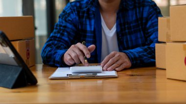 Küçük işletme girişimi Asyalı KOBİ Girişimcileri Ev, Ofis, Depo, Çevrimiçi Pazarlama Paketi Siparişleri Almak için Kutu ve Laptop ile çalışıyorlar. E-ticaret paket teslimatı kavramı