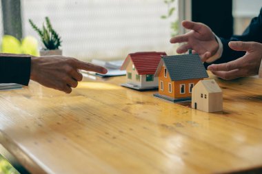 Satış temsilcisi bir ev satın alma sözleşmesi sunar ve projeyi yeni ev sahibinin müşterileri çalışma masasında satın alma ya da kiralama sözleşmesini imzaladıklarında onlara yakın olarak sunar..