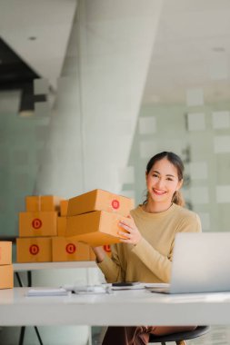 Bir KOBİ iş fikri başlatın, girişimci, genç Asyalı kadın, evden çalışan küçük işletme. Paketleme ve Nakliye serbest konsepti Dizüstü bilgisayarlarda çevrimiçi alışveriş 