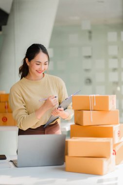 Bir KOBİ iş fikri başlatın, girişimci, genç Asyalı kadın, evden çalışan küçük işletme. Paketleme ve Nakliye serbest konsepti Dizüstü bilgisayarlarda çevrimiçi alışveriş 