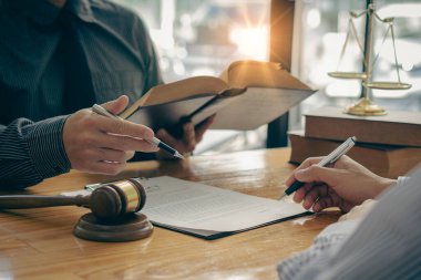 Avukat, Adalet Tanrıçası 'nın Çekiç ve Ölçeği ile imzalanmış bir sözleşmeyi masada ya da ofiste bir takım toplantısında sunar..