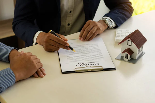 房地产经纪人或银行官员向签订了购房合同的客户解释贷款利息 并向办公室服务台提供产权租赁 — 图库照片