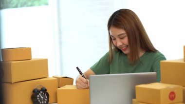 Genç Asyalı işletmeler online bir iş ya da bir fikirle başlar. KOBİ 'li genç kadınlar isim siparişleri almak ve teslimat için evlerinde kutu ve dizüstü bilgisayarlarla çalışıyorlar.