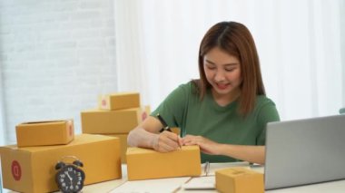 Genç Asyalı işletmeler online bir iş ya da bir fikirle başlar. KOBİ 'li genç kadınlar isim siparişleri almak ve teslimat için evlerinde kutu ve dizüstü bilgisayarlarla çalışıyorlar.
