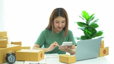 Genç Asyalı işletmeler online bir iş ya da bir fikirle başlar. KOBİ 'li genç kadınlar isim siparişleri almak ve teslimat için evlerinde kutu ve dizüstü bilgisayarlarla çalışıyorlar.