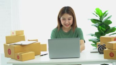 Genç Asyalı işletmeler online bir iş ya da bir fikirle başlar. KOBİ 'li genç kadınlar isim siparişleri almak ve teslimat için evlerinde kutu ve dizüstü bilgisayarlarla çalışıyorlar.