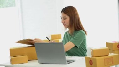 Genç Asyalı işletmeler online bir iş ya da bir fikirle başlar. KOBİ 'li genç kadınlar isim siparişleri almak ve teslimat için evlerinde kutu ve dizüstü bilgisayarlarla çalışıyorlar.