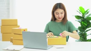 Genç Asyalı işletmeler online bir iş ya da bir fikirle başlar. KOBİ 'li genç kadınlar isim siparişleri almak ve teslimat için evlerinde kutu ve dizüstü bilgisayarlarla çalışıyorlar.