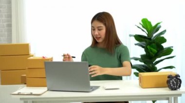 Genç Asyalı işletmeler online bir iş ya da bir fikirle başlar. KOBİ 'li genç kadınlar isim siparişleri almak ve teslimat için evlerinde kutu ve dizüstü bilgisayarlarla çalışıyorlar.