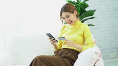 Asyalı kadınlar kredi kartlarını dijital mobil cihazlar kullanarak ve online alışveriş yaparak, akıllı telefonlara banka kartı numaralarını yazarak ve mobil bankacılık uygulamaları kullanarak işleterek tutuyorlar. çevrimiçi alışveriş kavramı