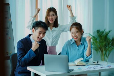 Üç Asyalı genç iş adamından oluşan bir grup modern bir ofiste yeni bir iş kurmak için beyin fırtınası konferans odasında iş tartışıyor..