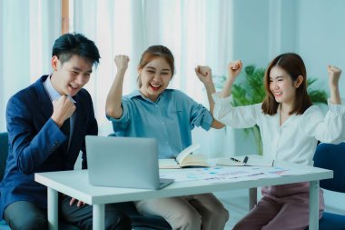 Üç Asyalı genç iş adamından oluşan bir grup modern bir ofiste yeni bir iş kurmak için beyin fırtınası konferans odasında iş tartışıyor..