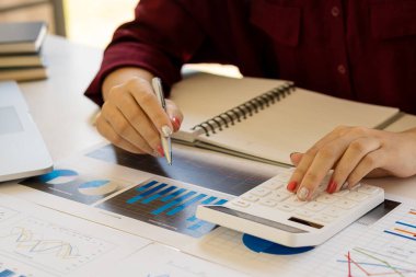 Şirket hesaplarından gelen rakamları hesaplamak ve yıllık mali raporları hazırlamak için beyaz hesap makinesine basan bir finans işadamının yakın çekimi. Finansal numaraların doğrulanması