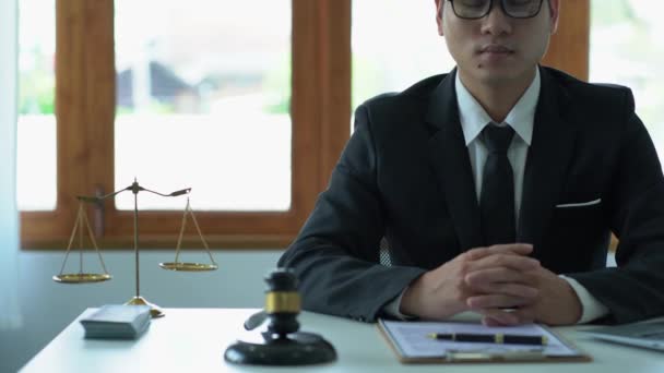 法廷のテーブルに木製のハンマーとラップトップで女神のスケールでオフィスで働くアジアの男性弁護士 正義と法の概念 Good Service Consulting — ストック動画
