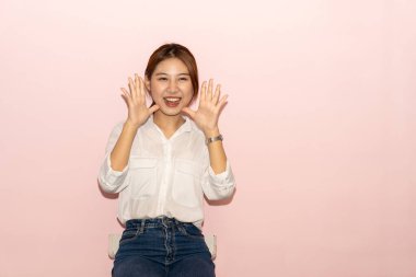 Beyaz elbiseli, siyah saçlı, tatlı Asyalı güzel bir kadının portresi nazik bir gülümsemeyle poz veriyor. Yalnız pembe bir arka planda