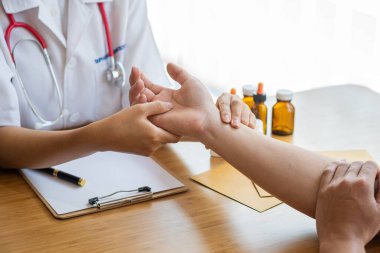 Image of a nurse checking a patient's pulse. A female doctor shakes hands giving her male patient reassurance and consultation.