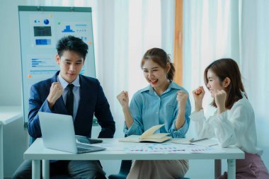 Takım olarak çalışan bir grup Asyalı iş adamı bir finansal tabloyu analiz eder ya da bir pazarlama planını tartışır. Kadın liderler yeni iş stratejileri sunar ve planlarlar. takım çalışması konsepti