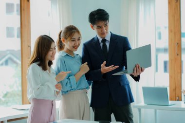 Takım olarak çalışan bir grup Asyalı iş adamı bir finansal tabloyu analiz eder ya da bir pazarlama planını tartışır. Kadın liderler yeni iş stratejileri sunar ve planlarlar. takım çalışması konsepti