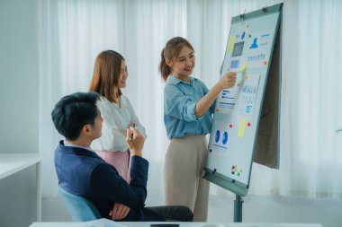 Takım olarak çalışan bir grup Asyalı iş adamı bir finansal tabloyu analiz eder ya da bir pazarlama planını tartışır. Kadın liderler yeni iş stratejileri sunar ve planlarlar. takım çalışması konsepti