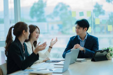Takım olarak çalışan bir grup Asyalı iş adamı bir finansal tabloyu analiz eder ya da bir pazarlama planını tartışır. Kadın liderler yeni iş stratejileri sunar ve planlarlar. takım çalışması konsepti