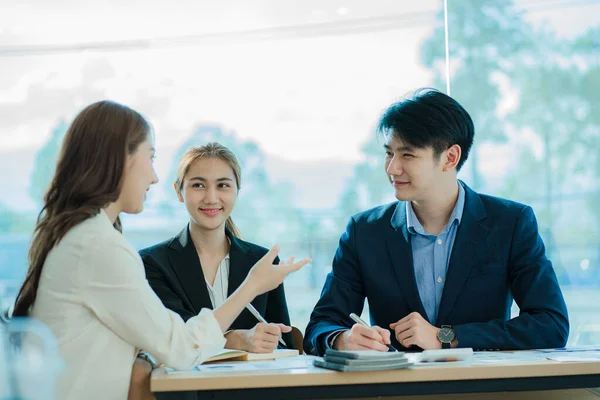 Takım olarak çalışan bir grup Asyalı iş adamı bir finansal tabloyu analiz eder ya da bir pazarlama planını tartışır. Kadın liderler yeni iş stratejileri sunar ve planlarlar. takım çalışması konsepti
