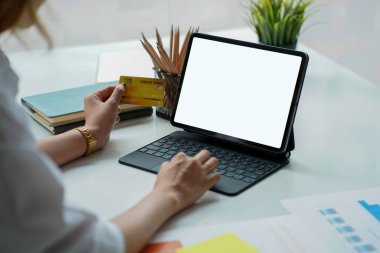 Kadın elleri tablet bilgisayar ve kredi kartı kullanarak alışveriş yapıyor. İnternet bankacılığı üzerinden çevrimiçi alışverişe yakın çekim
