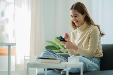 Kulaklık takan Asyalı ergen öğrenciler çevrimiçi öğrenim için video konferansı yoluyla iletişim kuruyorlar. Uygulamada ev konseptinde iş konferansı