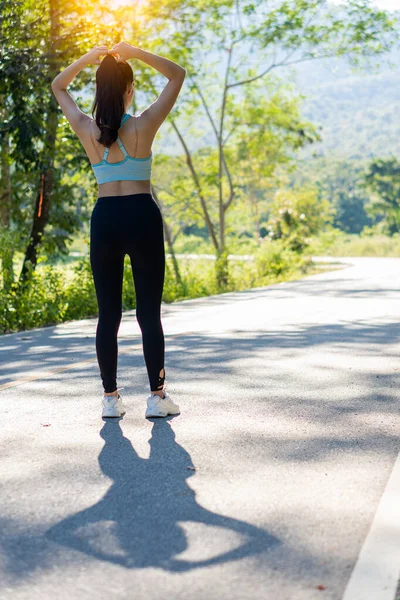 アジアの女性は健康のために運動する前に伸びます 屋外公園でストレッチしながら 水平画像 女性ランナーは夕方のランニングやジョギングのために暖まります — ストック写真