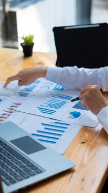 2 iş adamı kalem işaretli kağıt finansal grafik analizi ve iş ve muhasebeci için yatırım planlama toplantılarında dizüstü bilgisayarlı portre kullanarak çalışıyorlar.