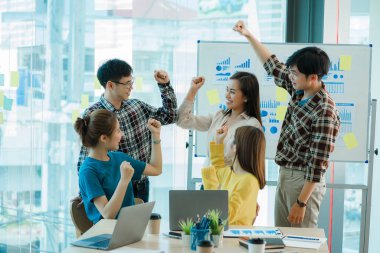 Bir grup Asyalı iş adamı dizüstü bilgisayarlarda beyin fırtınası yapıyor. Çalışmaya kararlı Asyalı genç iş adamlarının toplantısı. Yaratıcı iş ekibi ofiste birlikte oturuyor.