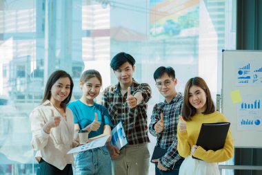 Bir grup Asyalı iş adamı dizüstü bilgisayarlarda beyin fırtınası yapıyor. Çalışmaya kararlı Asyalı genç iş adamlarının toplantısı. Yaratıcı iş ekibi ofiste birlikte oturuyor.