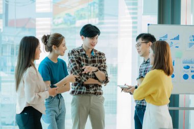 Bir grup Asyalı iş adamı dizüstü bilgisayarlarda beyin fırtınası yapıyor. Çalışmaya kararlı Asyalı genç iş adamlarının toplantısı. Yaratıcı iş ekibi ofiste birlikte oturuyor.