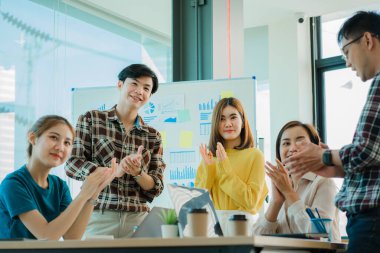 Bir grup Asyalı iş adamı dizüstü bilgisayarlarda beyin fırtınası yapıyor. Çalışmaya kararlı Asyalı genç iş adamlarının toplantısı. Yaratıcı iş ekibi ofiste birlikte oturuyor.