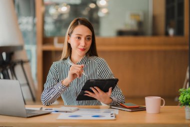 Asyalı iş kadını, matematik, vergi, muhasebe, istatistiksel raporlar ve analitik araştırma fikirlerinden para kazanmak için dizüstü bilgisayarını kullanıyor. Modern ofis gayrimenkul yatırım bilgileri