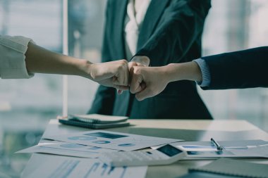 The new generation of young businessmen fist collide, feel the power of working together. or celebrate the start of a new project in a modern office meeting. teamwork support concept