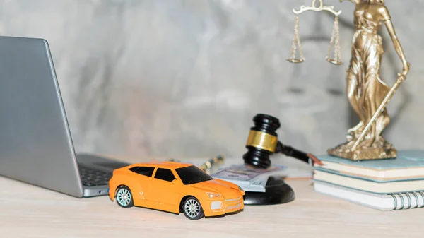 Orange car silver hammer laptop goddess of injustice financial authorization concept of car title