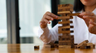 Kızın eli, kuleyi devirmeden tahta bloğu sökmeye çalıştı. beceri grubu oyunu İnşaat iş risk kavramı yakın plan resimlerin yanında metin için alan