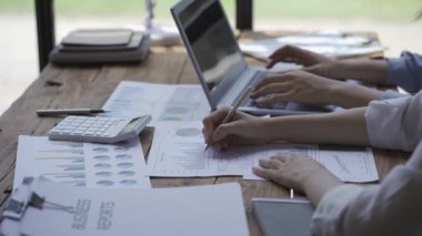 Bir finans analisti ve genç girişimcilerden oluşan bir planlama ekibi modern işletme firmalarının beyinlerini yıkamak için kağıtları kullanarak proje fikirlerini tartışıyorlar..