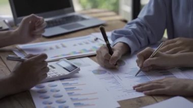 Bir finans analisti ve genç girişimcilerden oluşan bir planlama ekibi modern işletme firmalarının beyinlerini yıkamak için kağıtları kullanarak proje fikirlerini tartışıyorlar..