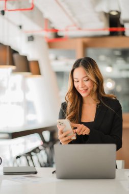 Akıllı telefon ve mobil hesap makinesi kullanan Asyalı iş kadınının elleri hesap makinesi ve hesap makinesi olan bir dizüstü bilgisayarda çalışıyor. çevrimiçi muhasebe kavramı
