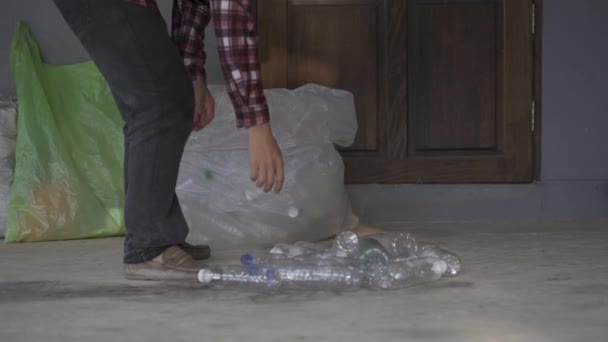 完全な収入としてリサイクルまたは販売するために明確なプラスチックボトルを収集若い男の4Kビデオ — ストック動画