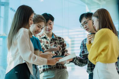 Bir grup Asyalı genç işadamı, yeni proje fikirlerini sunarak çalışmalarını tartışıyor ve tartışıyorlar. Toplantıda pazarlama ve yatırım planlarının analizi