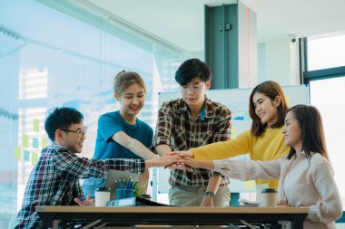 Takım çalışması ve işbirliği fikirleri için yapılan toplantıda, Asyalı İş Adamları Grubu 'nun İşbirliği Ofisi' nde El sıkışması genç insanların el sıkışması.