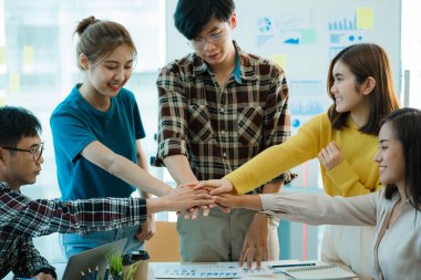 Takım çalışması ve işbirliği fikirleri için yapılan toplantıda, Asyalı İş Adamları Grubu 'nun İşbirliği Ofisi' nde El sıkışması genç insanların el sıkışması.