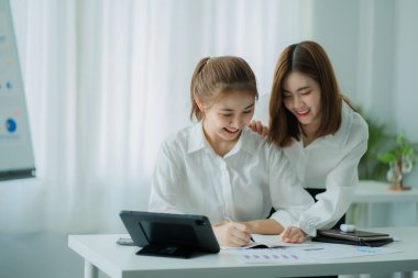 İki güzel Asyalı genç iş adamı dizüstü bilgisayarlarıyla bir masada oturup yeni projenin mali raporlarını tartışmak için evrak işleriyle uğraşıyorlar. Yeni nesil iş birliği kavramı