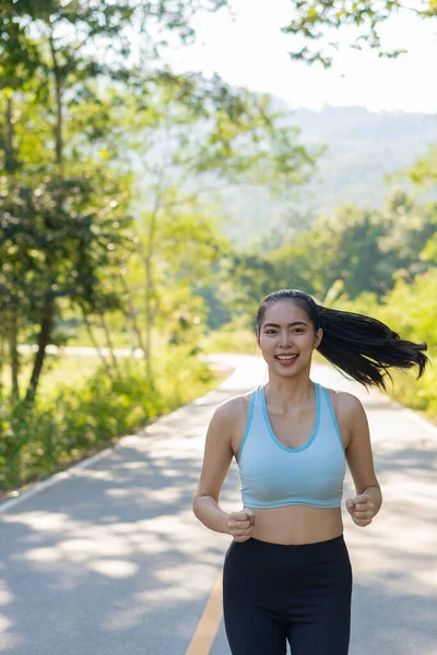 公園でジョギングアジアの女性 健康的なライフスタイルやスポーツの概念 美しい夏の日に太陽の下公園をジョギングする女性は — ストック写真