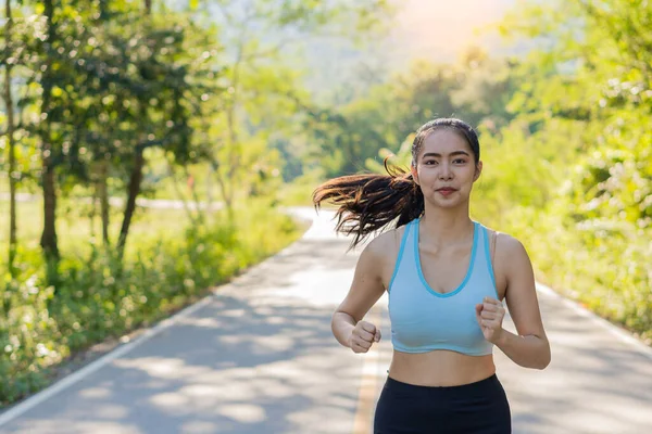 公園でジョギングアジアの女性 健康的なライフスタイルやスポーツの概念 美しい夏の日に太陽の下公園をジョギングする女性は — ストック写真