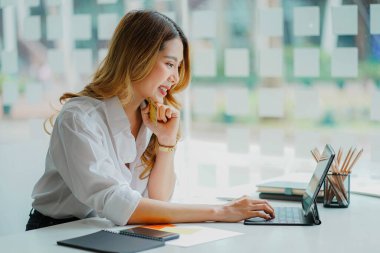 Modern ofiste sekmeler üzerinde çalışan serbest çalışan Asyalı genç iş kadını bir hesap analizi raporu hazırladı. Gayrimenkul yatırım bilgileri finansal ve vergi sistemi kavramları